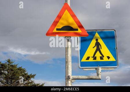 Deux panneaux de signalisation sur un seul poteau, la sécurité pour les personnes qui passent la route. Parties d'un ciel bleu, entouré par des nuages pluvieux intenses en automne. Haut de Banque D'Images