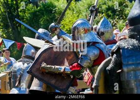 Les restaurateurs médiévaux se battent avec des épées en armure lors d'un tournoi de chevaliers Banque D'Images