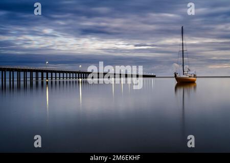 Bateau à voile ancré près de la jetée d'Urangan dans la lumière du matin. Hervey Bay, Queensland Australie Banque D'Images