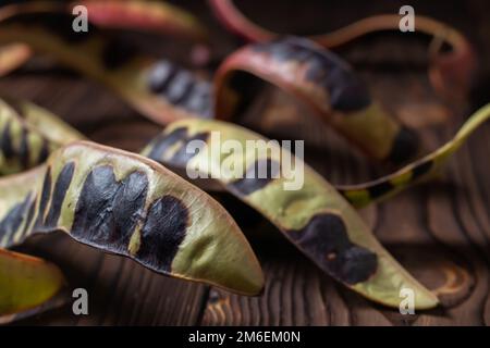 Graines d'acacia sur fond de bois. Gros plan. Banque D'Images