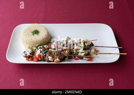 La vie de la dishe culinaire africaine. Brochette de bœuf Choukouya avec accompagnement Attieke Banque D'Images