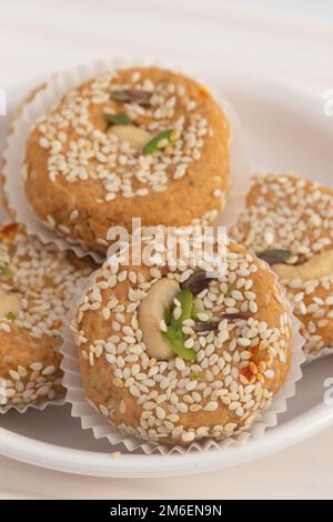 Saison d'hiver spécial Punjabi traditionnel Mithai jusqu'à Tikki ou Tilkut gud Mawa Bati est fait de graines de sésame grillées à sec avec Mava, Khoya, Jaggery, Gur, Banque D'Images