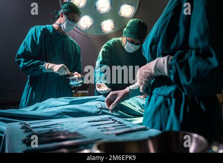 L'infirmière de la salle d'opération envoie l'équipement chirurgical au médecin chirurgien Banque D'Images