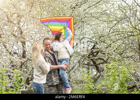 Soldat réuni avec sa famille dans le parc. Banque D'Images