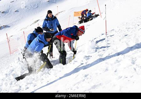 Grainau, Allemagne. 04th janvier 2023. Les guides de montagne et les gardes de montagne de la police recherchent une personne enterrée dans la neige au Zugspitzplatt lors d'une démonstration pratique sur la recherche de victimes d'avalanches. Des experts du club alpin allemand, du Service de sauvetage de montagne, de l'Association allemande des moniteurs de ski, du Service d'alerte aux avalanches et des guides de montagne de la police se sont réunis pour une conférence de presse sur la sécurité alpine. Credit: Angelika Warmuth/dpa/Alamy Live News Banque D'Images