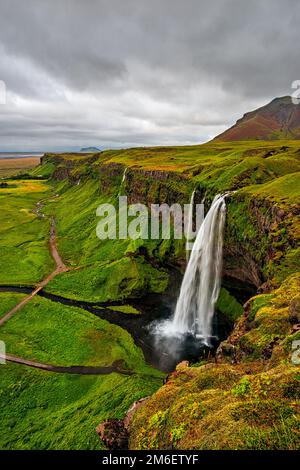 Chute d'eau de Seljalandsfoss en un jour nuageux, Islande Banque D'Images