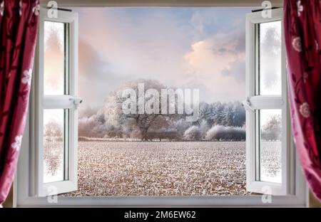 Vue à travers la fenêtre ouverte pour une vue magnifique sur le paysage rural d'hiver. Rideaux rouges et fenêtres modernes à double vitrage Banque D'Images