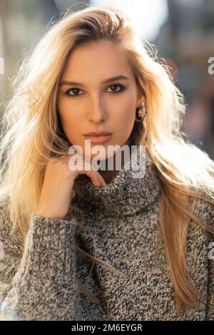 Portrait de jolie jeune femme en chandail regardant l'appareil photo à New York, image de stock Banque D'Images