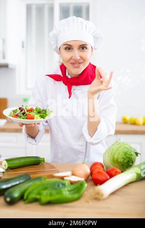 Chef féminin avec assiette de salade de légumes Banque D'Images