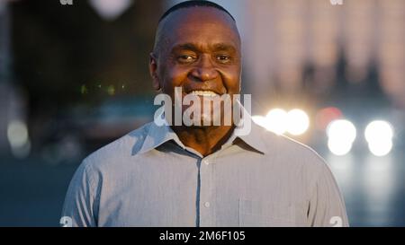 Gros plan portrait masculin en ville à l'extérieur afro-américain adulte d'âge moyen homme posant dans la rue sourire joyeux visage de type avec des rides réussi mûr Banque D'Images
