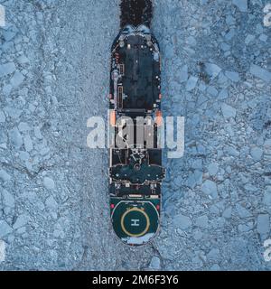 Bateau navigue sur une baie de glace. Navigation de mer en hiver. Banque D'Images