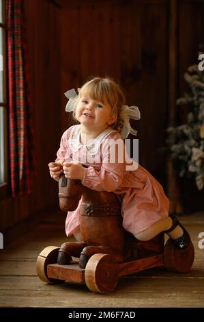 Petite jolie fille blonde debout à la tête de lit de fer Banque D'Images