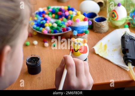 Une fille peint magnifiquement des œufs de Pâques Banque D'Images