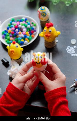 Les mains de l'enfant tiennent un œuf peint comme un cadeau à fêtez pâques Banque D'Images