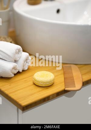 Barre de shampooing solide durable, serviettes ana peigne en bois sur une table en bambou. Sans plastique, sans déchets, ingrédients à faible teneur en eau. Soin des cheveux écologique. Banque D'Images