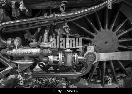 Noir et blanc, vue latérale rapprochée d'une ancienne locomotive à vapeur britannique vintage, roue et piston. Banque D'Images