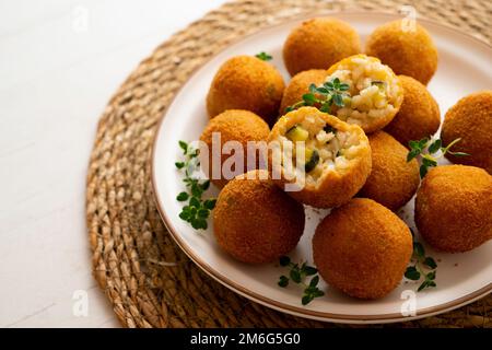 L'arancini est une spécialité de la cuisine sicilienne. Ils sont farcis panés et frits boulettes de riz ou cônes Banque D'Images