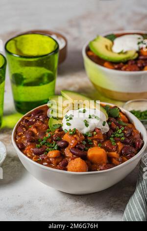 Patates douces au piment et haricots noirs avec tomates, céleri dans une poêle sur la table. Vue de dessus horizontale Banque D'Images