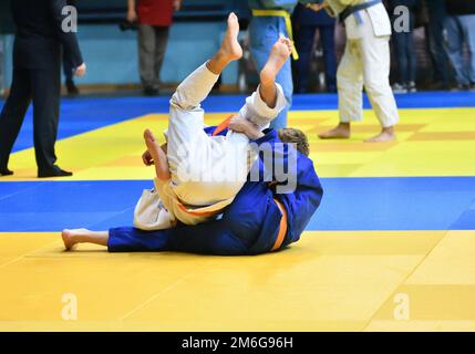 Deux garçons judoka dans kimono concourent sur le tatami Banque D'Images