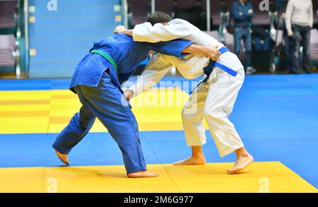 Deux garçons judoka dans kimono concourent sur le tatami Banque D'Images