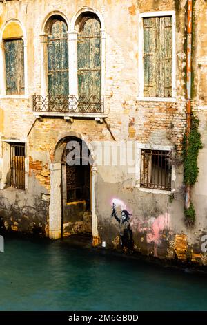 VENISE, ITALIE - 26 NOVEMBRE 2022 : eaux du canal de Venise, portail et graffiti de Banksy avec exposition longue pendant l'hiver 2022 Banque D'Images