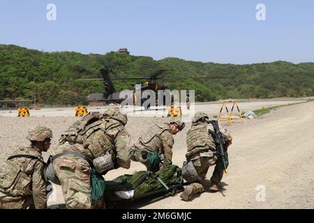 Une équipe de soldats travaille ensemble pour approcher un américain L'hélicoptère militaire HH-60 Medevac pour charger un patient pendant l'entraînement semestriel au champ de tir Rodriquez Life en mai. Pacific Medics Lift est un exercice d'entraînement semestriel qui simule des tâches et situations médicales militaires réelles potentielles pour inclure des scénarios d'évacuation médicale. Banque D'Images