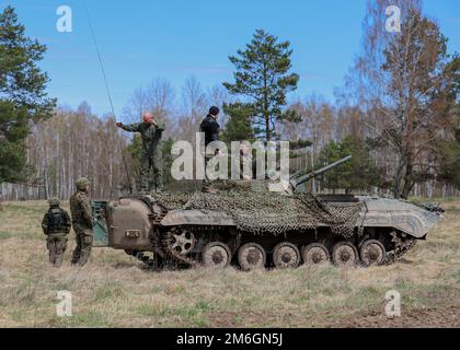 Zone d'entraînement de Bemowo Piskie, Orzysz, Pologne - soldats polonais une partie de la Brigade d'infanterie mécanisée de 15th s'entretient avec des soldats de la Force de défense territoriale polonaise après avoir exploité un char mécanisé lors de la dernière journée d'entraînement de l'exercice Thunderbolt Focus 2022, 27 avril. Les soldats polonais, entre autres, des nations alliées ont travaillé ensemble dans des équipes dynamiques contre les tactiques, les techniques et les procédures utilisées par les forces ennemies qui ont permis aux groupes de combat de pratiquer, affiner et valider toutes les compétences en matière de combat, d'interopérabilité et de contrôle. Banque D'Images