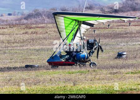 Vol sur un parapente motorisé en terrain montagneux Banque D'Images