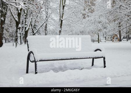 Banc sous la neige dans le parc en hiver. Banque D'Images