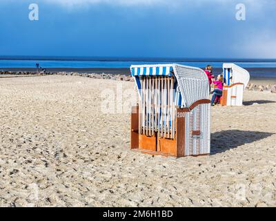 Chaise de plage verrouillée sur une plage de sable vide, vue sur la mer des Wadden en automne, Utersum, Schleswig-Holstein Parc national de la mer des Wadden, île de Foehr Banque D'Images