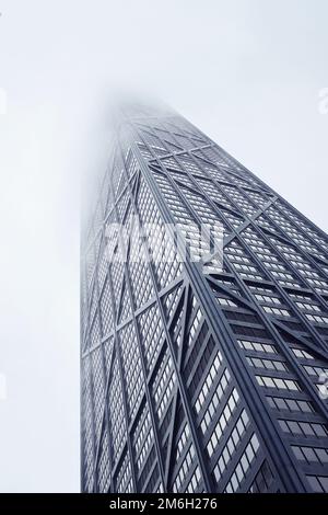 Détail du bâtiment John Hancock vu d'en dessous, comme il disparaît dans un nuage brumeux bas en hiver, par une journée de gris Banque D'Images