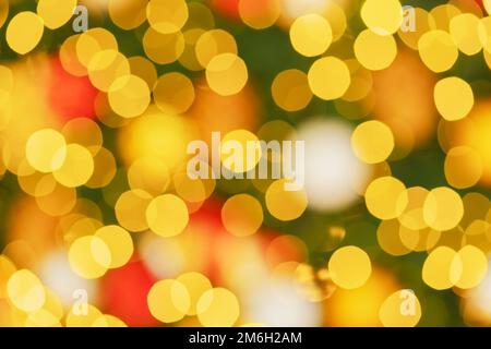 Effet de flou sous forme de bokeh circulaire jaune vif. Bokeh sur le fond d'un arbre de Noël flou. Contexte i Banque D'Images