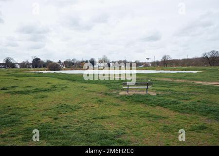 Vue sur un étang déserté et un banc vide sur wimbledon Common Banque D'Images