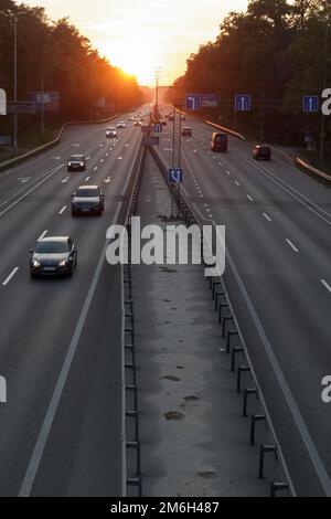 Déplacement de voitures sur l'autoroute au coucher du soleil.Circulation routière au coucher du soleil avec voitures.Circulation très fréquentée sur l'autoroute, vue sur la route. Banque D'Images