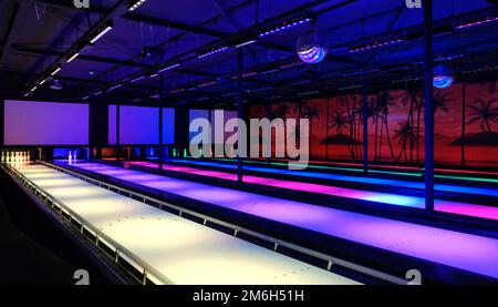 Piste de bowling avec lumières au néon dans des ruelles bleues, rouges et blanches Banque D'Images