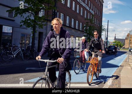 Les cyclistes traversent un carrefour routier à Copenhague, au Danemark Banque D'Images