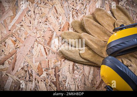 Gants de protection en cuir, cache-oreilles sur panneau. Banque D'Images