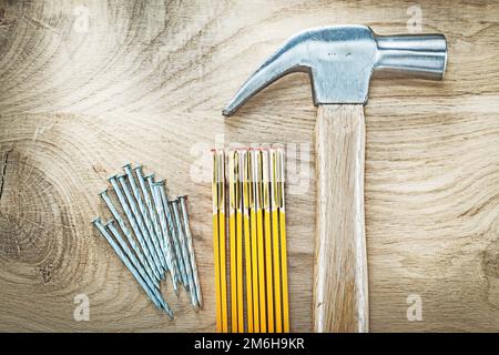 Jeu de clous de construction de compteur en bois de marteau à griffe sur le concept de construction de panneau en bois. Banque D'Images