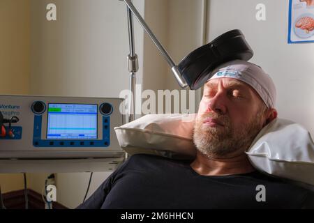 Montréal, CA - 15 novembre 2022 : patient subissant une stimulation magnétique transcrânienne répétitive (TMS) pour traiter l'anxiété et la dépression Banque D'Images