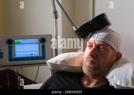 Montréal, CA - 15 novembre 2022 : patient subissant une stimulation magnétique transcrânienne répétitive (TMS) pour traiter l'anxiété et la dépression Banque D'Images