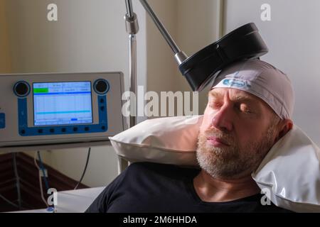 Montréal, CA - 15 novembre 2022 : patient subissant une stimulation magnétique transcrânienne répétitive (TMS) pour traiter l'anxiété et la dépression Banque D'Images