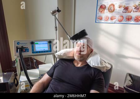 Montréal, CA - 15 novembre 2022 : patient subissant une stimulation magnétique transcrânienne répétitive (TMS) pour traiter l'anxiété et la dépression Banque D'Images