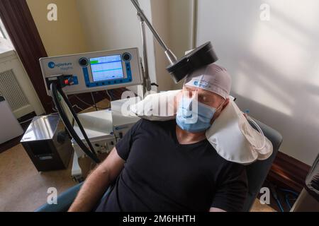 Montréal, CA - 15 novembre 2022 : patient subissant une stimulation magnétique transcrânienne répétitive (TMS) pour traiter l'anxiété et la dépression Banque D'Images