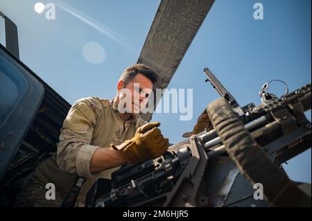 Le sergent d'état-major Dominic Brinker, instructeur d'aviateur des missions spéciales du 66th Escadron de sauvetage (SQS), inspecte une mini-arme lors des contrôles préalables au vol à la base aérienne de Nellis, Nevada, 28 avril 2022. La mission des NQS de 66 est de fournir des forces de recherche et de sauvetage de combat rapidement déployables, expéditionnaires et agiles en réponse à des opérations d'urgence dans le monde entier. Banque D'Images