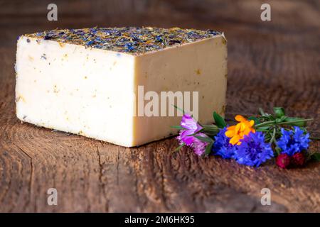 Fromage de montagne avec fleurs sur bois Banque D'Images