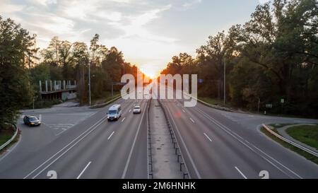 Déplacement de voitures sur l'autoroute au coucher du soleil.Circulation routière au coucher du soleil avec voitures.Circulation très fréquentée sur l'autoroute, vue sur la route. Banque D'Images