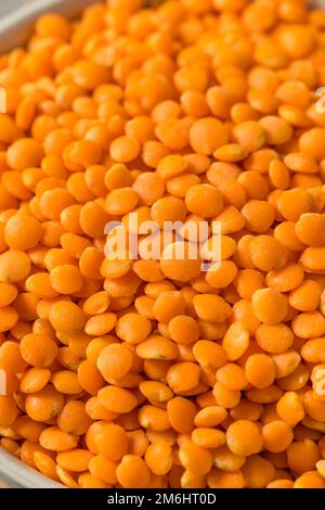 Lentilles rouges biologiques crues légumineuses dans un bol Banque D'Images