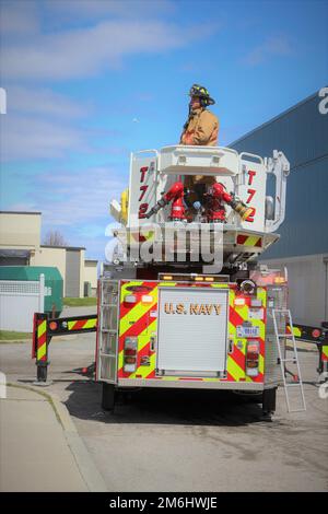 Les membres de la base navale des services de sécurité et d'incendie et d'urgence de Newport répondent à un appel de plusieurs personnes bloquées sur le toit d'un bâtiment pendant l'exercice Citadel Gale 2022 à l'installation. Dans ce scénario, le bâtiment est inondé d’eau et l’eau stagnante nécessite l’utilisation de la tour 72 pour pouvoir atteindre le groupe et les extraire du toit du bâtiment. Il s’agissait de l’un des trois exercices de formation axés sur le feu qui ont été inclus dans les injections de forage de l’installation dans le cadre de l’exercice annuel sur les ouragans. Banque D'Images