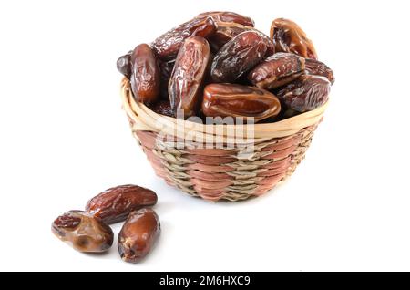 Dates dans un panier sur fond blanc avec une ombre molle Banque D'Images