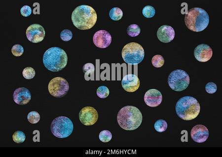 Planètes peintes avec des peintures à l'aquarelle brillantes sur du papier aquarelle noir. Cercles d'aquarelle lumineux avec un lustre métallique sur fond noir. Extérieur Banque D'Images